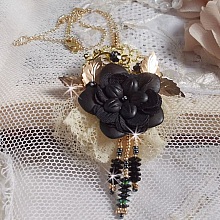 Pendentif Attrapes R&ecirc;ves brod&eacute; avec des fleurs Lucites Noires sur une dentelle Beige et une estampe dor&eacute;e. Les pendants sont des fleurs en cristal avec des rocailles. Mont&eacute; avec une cha&icirc;ne plaqu&eacute; Or